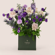 Square flower box with quicksand roses, purple lisianthus, light purple carnations, delphiniums, and eryngium in TWIGS beige or green packaging, available for same day flower delivery in Dubai when you buy flowers online.