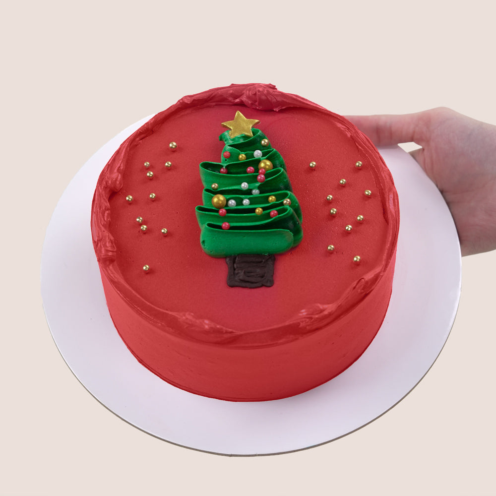 Red frosted cake with a Christmas tree decoration. The most delicious cake in Dubai. 