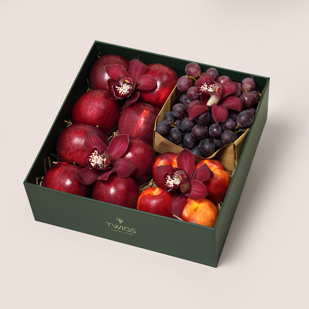 TWIGS Red Box with fresh red apples, nectarines, dark grapes and burgundy cymbidium orchids in a dark green gift box, Dubai UAE