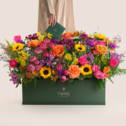 Colorful bouquet of flowers in a green garden box by TWIGS UAE