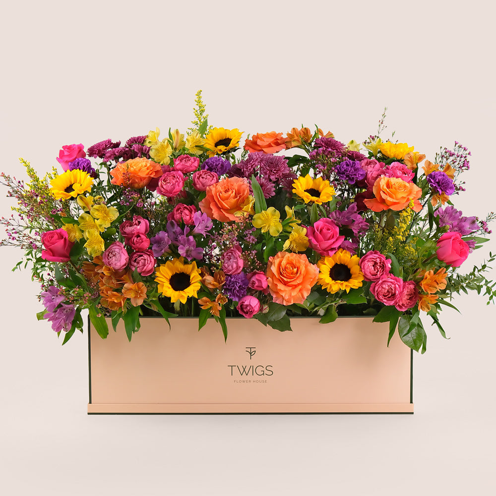 Colorful flower arrangement in a box with 'TWIGS' 