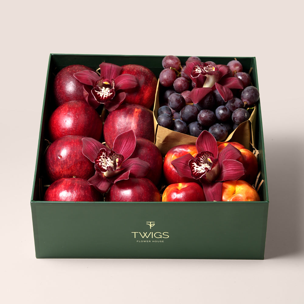 TWIGS Red Box with fresh red apples, nectarines, dark grapes and burgundy cymbidium orchids in a dark green gift box, Dubai UAE