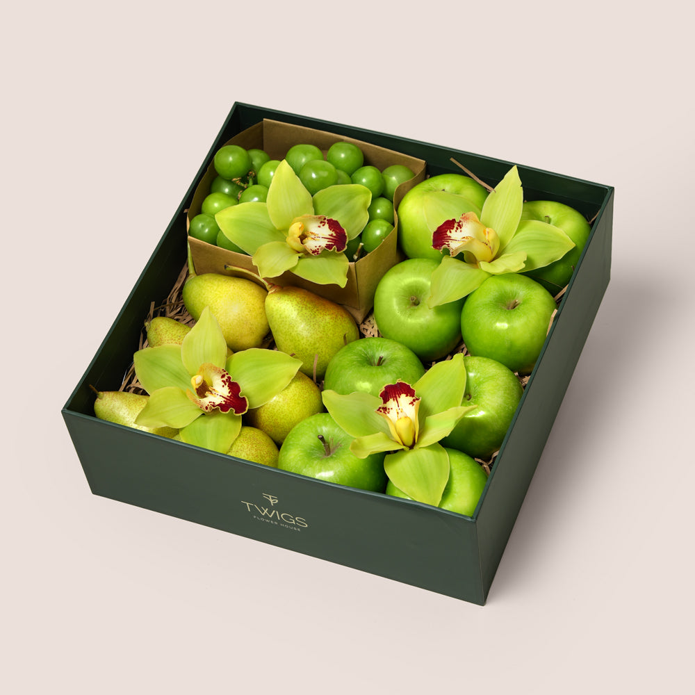 TWIGS Green Box with fresh Granny Smith apples, green pears, green grapes and yellow cymbidium orchids in a dark green gift box, Dubai UAE