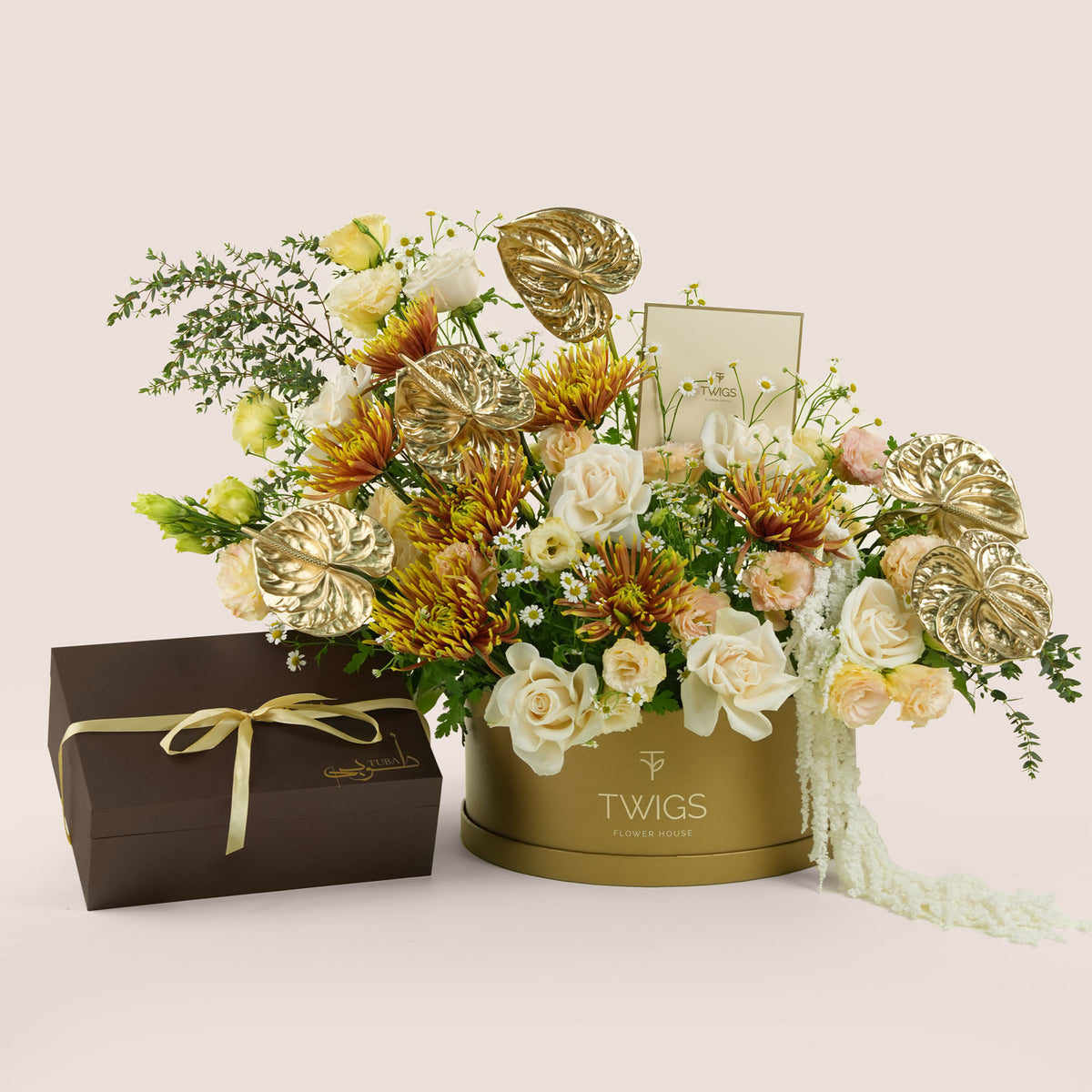 Aurelia, a luxury TWIGS Gold Grande arrangement of white and peach roses, chrysanthemums, and gold anthurium leaves, paired with the Tuba Jelani bakhoor gift set by Light of Sakina.