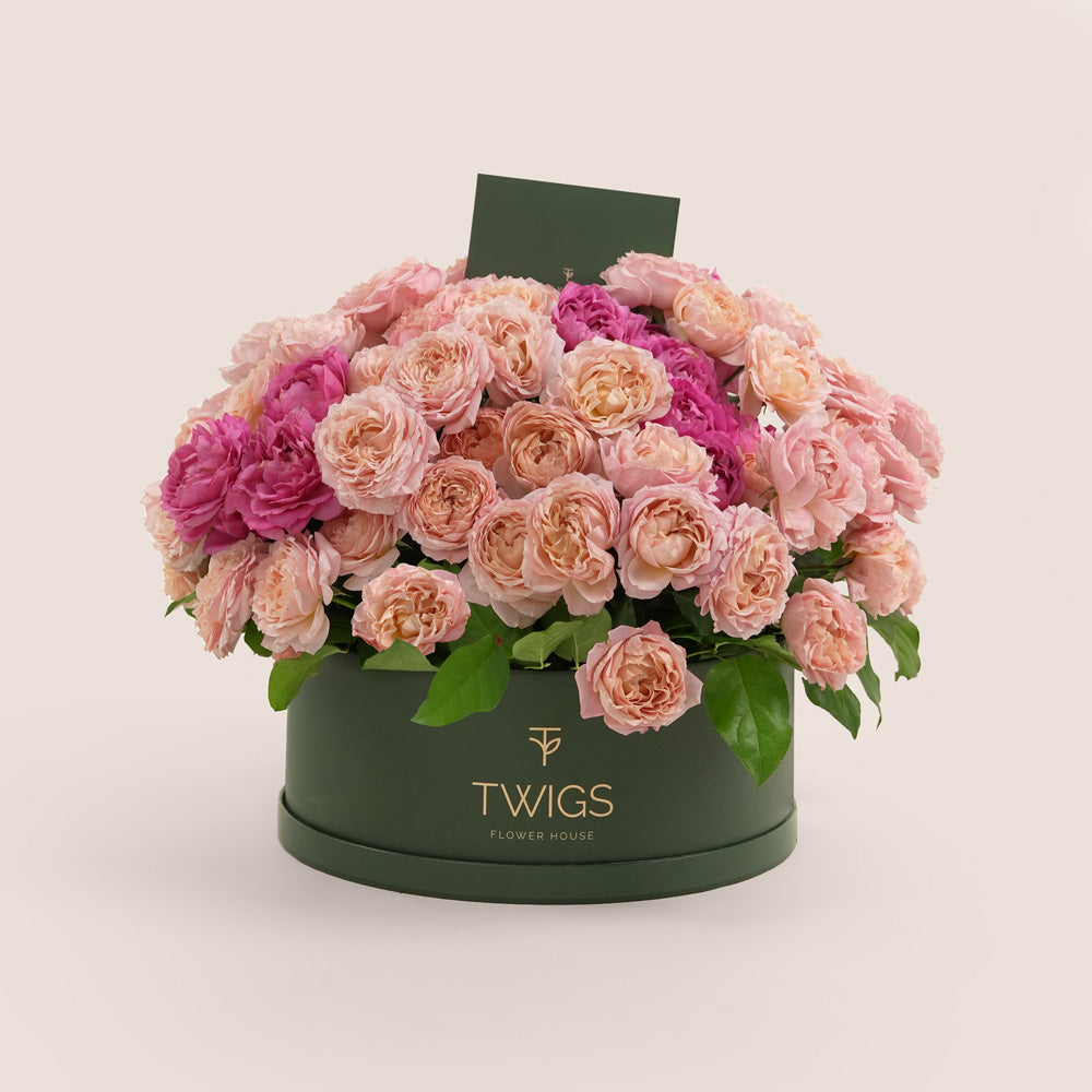 Grande round flower box with premium Juliet spray roses and cerise accents in TWIGS beige or green packaging, available for same day flower delivery in Abu Dhabi when you buy flowers online.