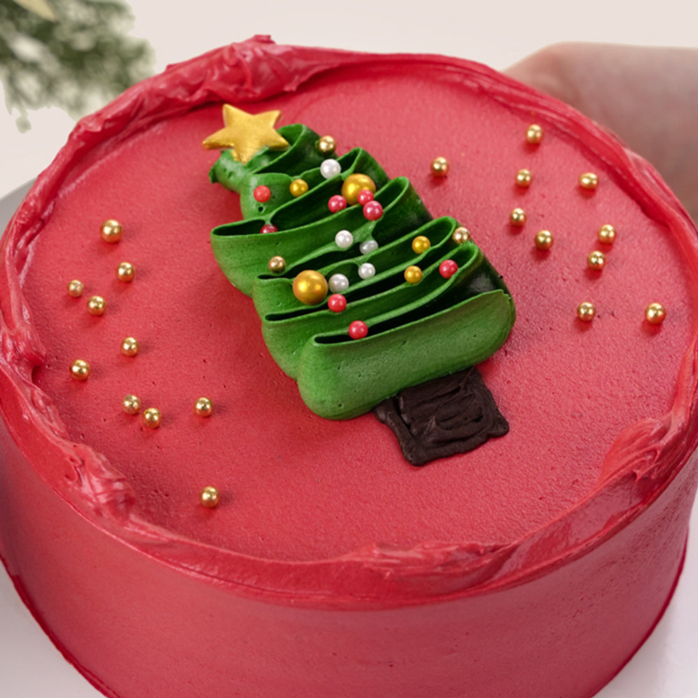 A beautiful festive flower bunch featuring a vibrant red Christmas flower arrangement placed beside a decorated cake