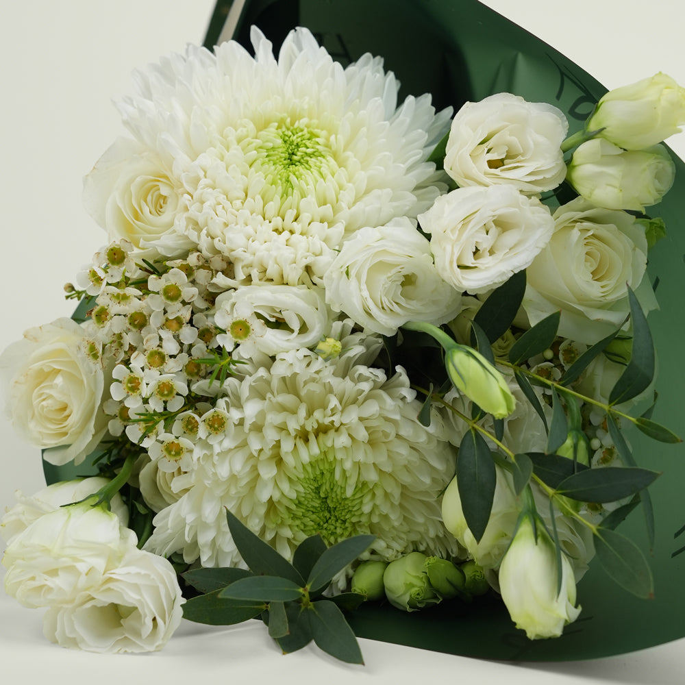 Bouquet of white flowers with green accents on a light background