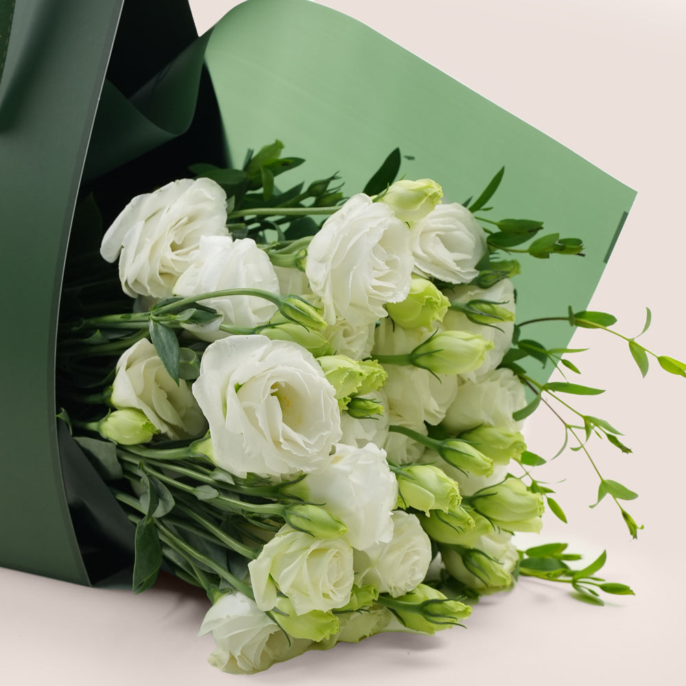 Bouquet of white and green flowers wrapped in green paper by TWIGS Flower House