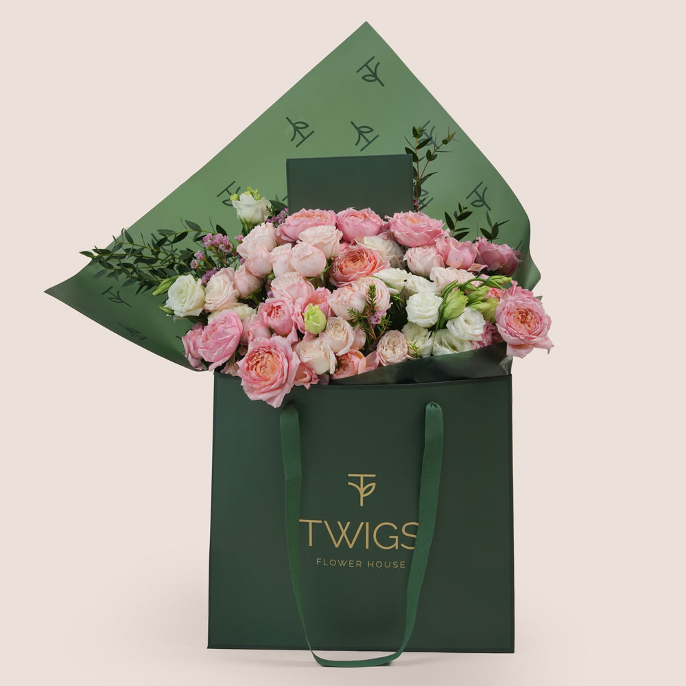Blushing Bloom Mother’s Day flower arrangement with Juliet spray roses and white lisianthus in TWIGS signature flower bag