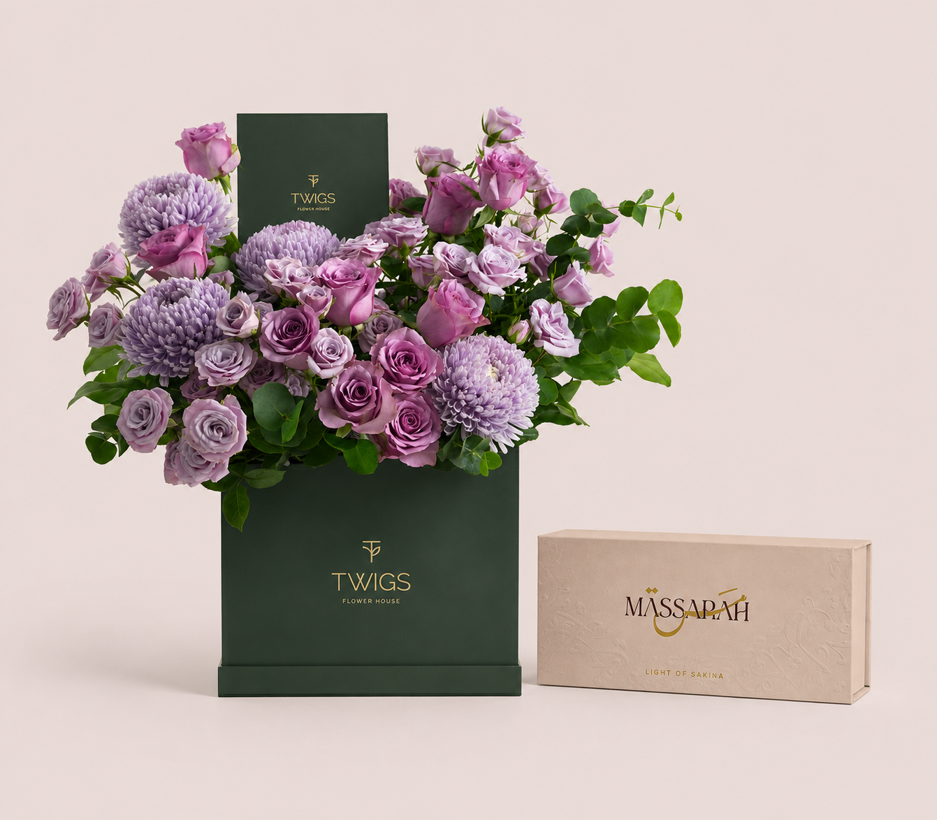 Purple roses and lilac chrysanthemums in a tall green TWIGS box beside a Massarah Her perfume oil set, TWIGS x Light of Sakina collaboration