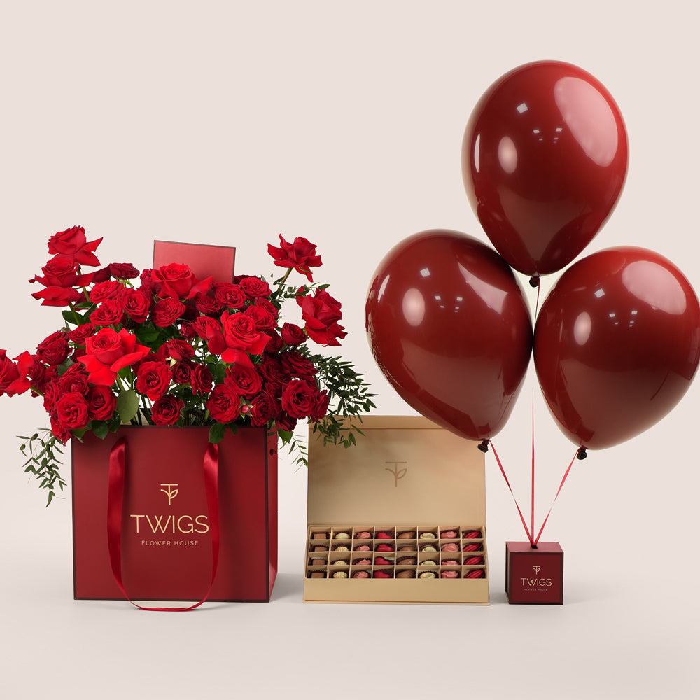 luxury red roses bouquet in burgundy gift bag with balloons and chocolates valentine’s day delivery uae